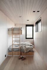 Eivind wanted to find a contemporary, minimalist take on the <i>hytte</i> that would still evoke the requisite sense of <i>koselig</i> (warmth, contentment, coziness) he recalls from his childhood. Vaulted ceilings in a warm, pale pine paneling are juxtaposed with glossy black accents. Light pours through the panoramic windows that blur the line between indoor and outdoor.
