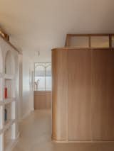 Oak walls with integrated storage and clerestories supply sleekness for the hallway.