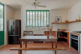 Mint green-painted ironwork and tiles connect the indoors to the outside more fluidly.
