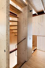 A staircase winds up through the center of the house. Its structural spine is made of cross-laminated timber, while the screen that encloses it is made from slats of South African pine. “The timber screen separates the stair from the surrounding space but still allows glimpses through,” says Douglas. “It recalls Japanese screens, especially at night when it lights up like a lantern.”