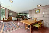 Floor-to-ceiling glass doors open the living room to one of the residence’s three terraces. The 1953 Michigan home still has its original flooring, concrete block walls, and wood trim.