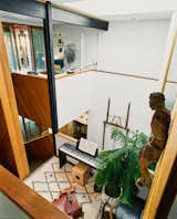 The central stair landing doubles as a music room. "In many ways this is the center of our home," says Rick. "The entire house literally circles it." Hanging on the wall is a 16th-century Tyrolean wood figure of Christ purchased from the original owners.
