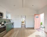 The open-plan kitchen, dining area, and living space are arranged in a 16-square-foot volume that features a vaulted ceiling, lending a sense of spaciousness.