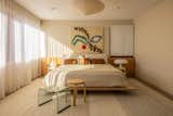 The basement-level guest bedroom features a painting by Marleigh Culver. An Alvar Aalto Stool 60 sits with a 1973 Onda Incisa stool by Vittorio Livi. The ’60s lamp to the left of the bed by Paul Mayén and one on the right, a Nesso by Giancarlo Mattioli, rest on matching Giano-Giano-Vano nightstands by Emma Gismondi Schweinberger.