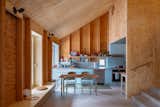 "The name ‘Unfinished House’ refers to an aesthetic attitude... self-finishing materials were selected to reduce resources and reveal the building’s construction. Tile and plywood are the only added finishes; they cover areas with wiring and plumbing," the architects tell us. "The building is an all-timber structure with cellulose and wood fiber board insulation. Many of the materials were locally-produced including the wood framing, plywood, corrugated metal, and wood cladding."