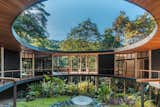 "While the home is on a single level, the terrain around it descends steeply," explains Studio Saxe. "One side aligns with the forest floor, while the other is raised above the ground. The perimeter walkway takes visitors from moss-covered roots up to the treetops." The deep roof, slatted screens, and raised foundation are designed for the region’s tropical climate, while photovoltaic and hydroelectric systems make the home self-sufficient. Because of the remote site, the steel components were prefabricated and delivered during the dry season.