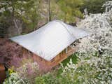 Architect Jean-Baptiste Barache describes the metal roof of this Normandy residence as essentially a deformed plane, placing an apple beneath a sheet of paper to demonstrate his point. He chose zinc for its malleability and the high level of the craftspeople who work with it.