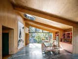 Colors of an exterior wall in this São Paulo home are reflected throughout, such as in the Brazilian green marble floors in the kitchen/living area, as well as built-in kitchen cabinetry, covered in Salmon Formica. Tito designed the dining table.